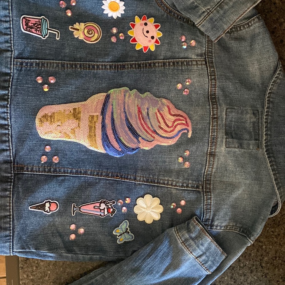 Girls Jean jacket decorated with patches and rhinestones.